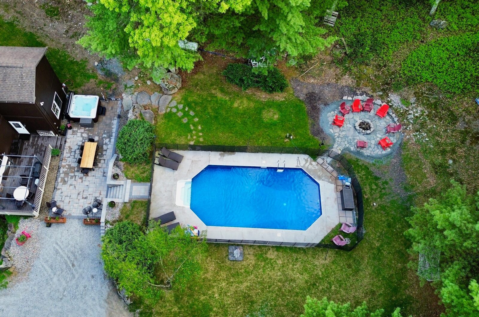 Aerial view of pool, hot tub, patio, and fire pit